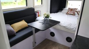 Fixed bed and convertible dinette layout options inside a compact Ecocampor caravan
